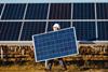A photo of a worker carrying a solar panel