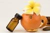 A photograph of orange peel and a bottle of essential oil