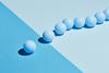 An image showing a blue sphere leading a group of blue spheres across a boundary between differently coloured areas