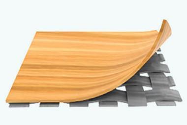 A layer of a wooden material is peeled back to reveal a woven material underneath