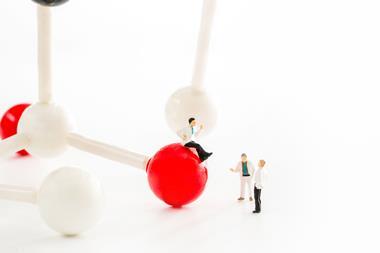 Miniature scientist observing and discussing about chemical bond