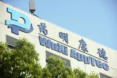 A sign in English and Chinese for Wuxi AppTec on the side of a office block